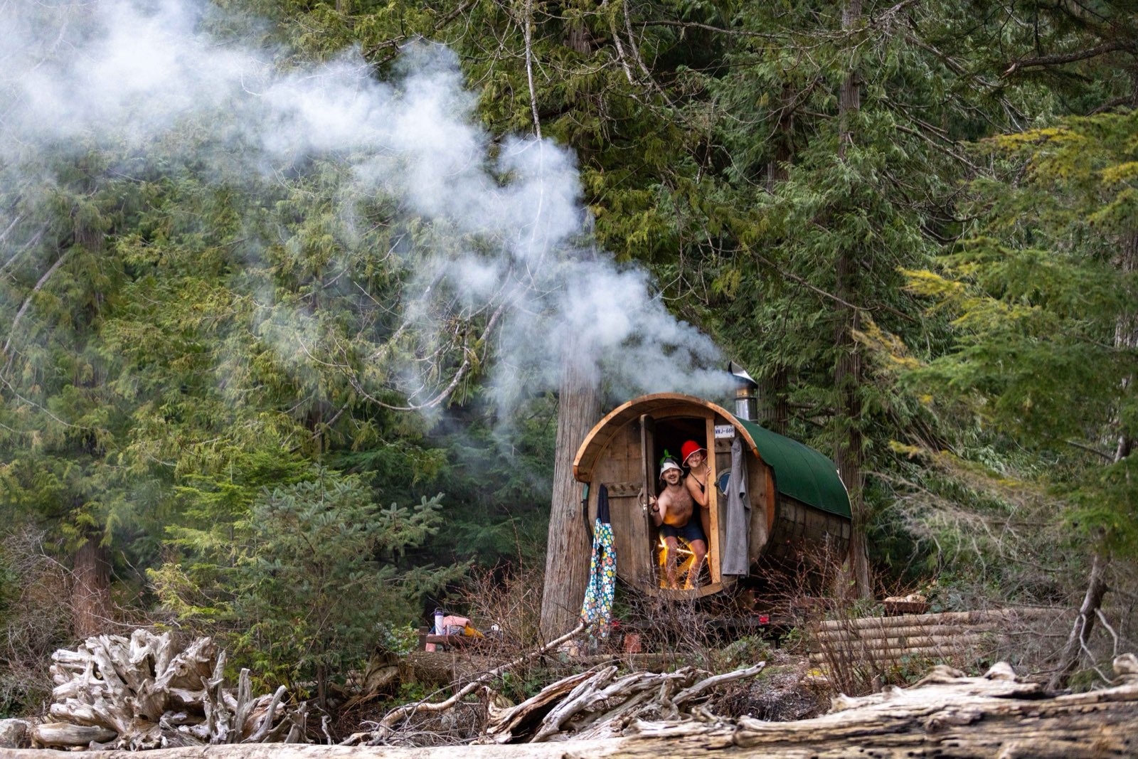 Steam rising off two people outside the wood-fired sauna